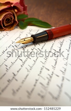 Old letter on a desk with a fountain pen on top