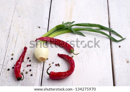 Green onions and red peppers spicy, colorful pepper on old wooden table top