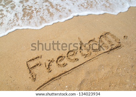 Word FREEDOM on the beach.