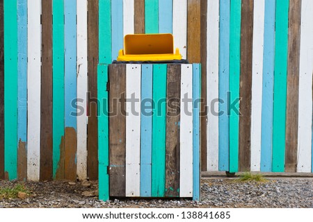 Yellow bins. Multicolored wooden wall.