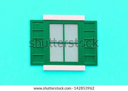 Vintage green and white window on green brick wall