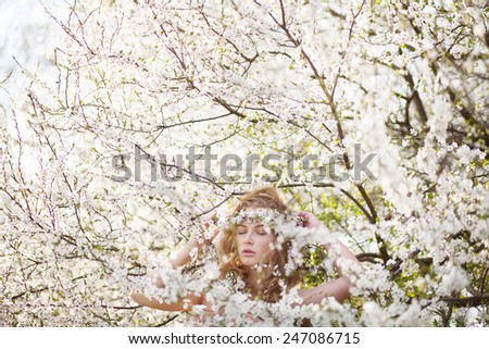 mysterious beautiful girl with flowers in her hair. Queen blooming gardens. Fields of flowers