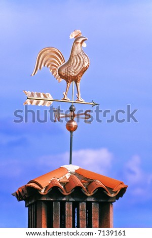 A weathercock indicates wind direction on a chimney pot