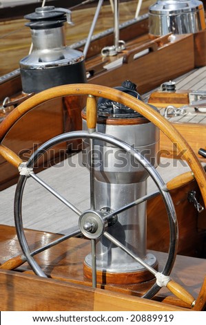 Detail of an old-fashioned boat deck with rudder, compass and other navigation tools