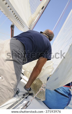 Man on a boat with sails and ropes