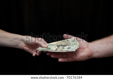 A woman hands a man five twenty dollar bills. Closeup, cutout, black background. Hands and forearms only.