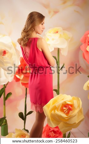 photo shoot of a beautiful girl in the flowers in the studio with defocused background