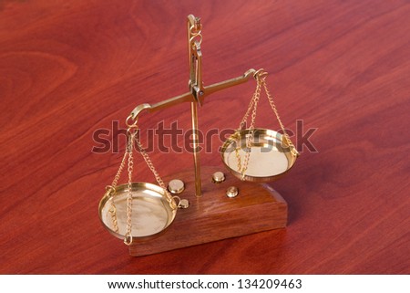 Golden scales of justice on wooden table, isolated on white background.