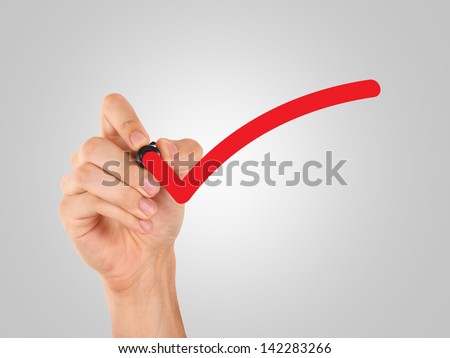 Hand draws red tick, approval sign.