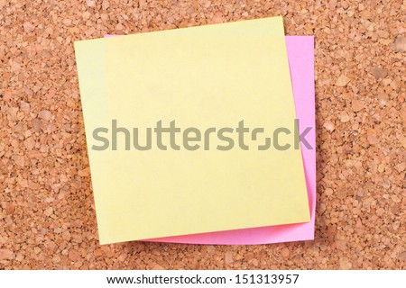 Blank, empty, yellow sticky post it note for your message on cork bulletin board.