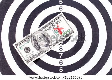 Red arrow and one hundred dollar bill on dart board.