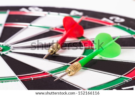 Plastic, red and green arrows on dart board, isolated on white background.