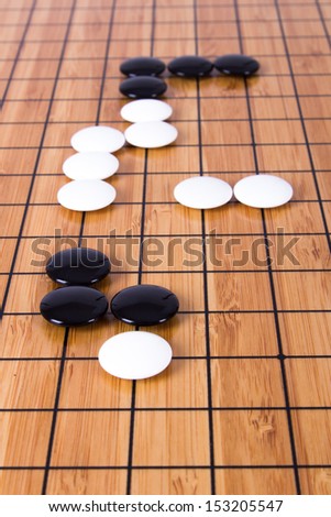 Close up view of black and white stone pieces on Chinese go game board.