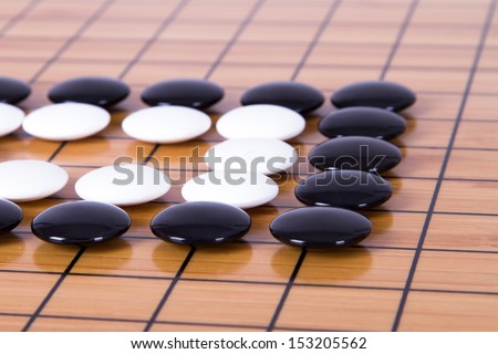 Black and white figures on squares, Chinese go game on board.