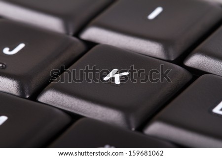 Black computer keyboard buttons, focused on a letter.