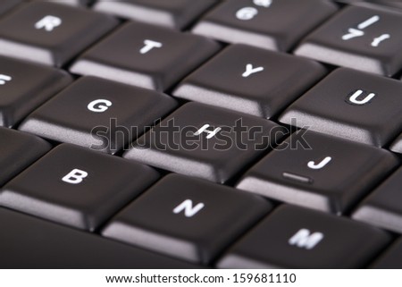 Black computer keyboard buttons, focused on letters.