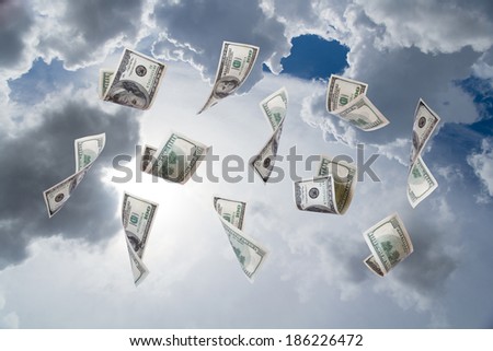 Dollar banknotes falling down on cloudy sky background.