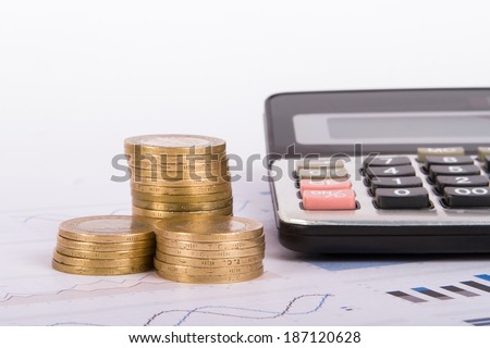 Money and calculator on financial data bar charts.