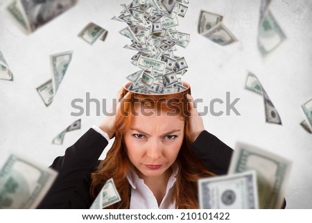 Red head woman holding her head with angry emotion, expression and dollar banknotes instead of brain flowing around, isolated on grunge, white background.