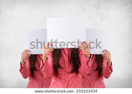 Young three women holding blank, white cards with copy space on face with grunge background.