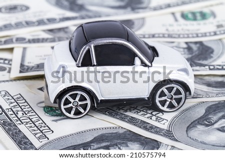 One hundred dollar banknotes with small, toy car.