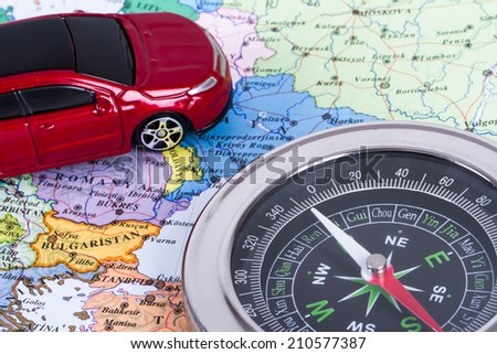 Travel concept, compass and small, toy car map, isolated on white background.