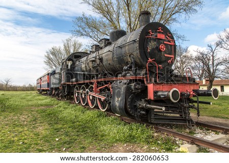 Side view of black old train wagon, in cloudy sky.