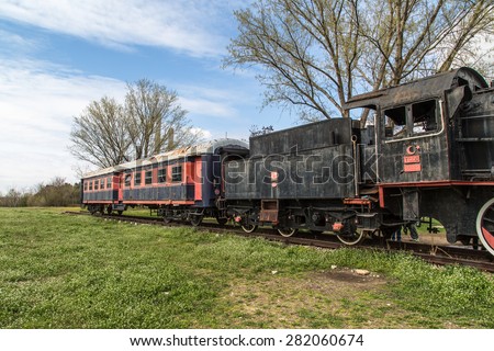 Side view of black old train wagon, in cloudy sky.