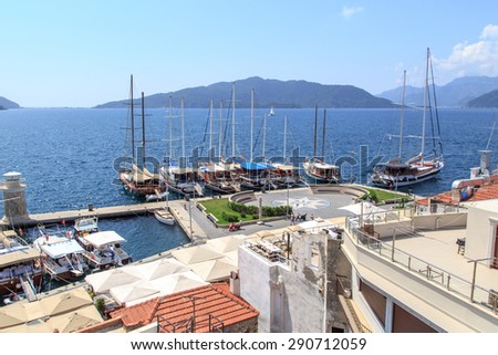 MUGLA, TURKEY - JUNE 1, 2015 : Top view of Marmaris Marina among mountains with sailing boats and yatches anchored, on blue sky background.