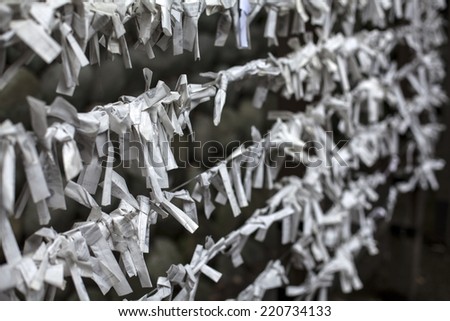 Wishes are written on paper and tied to a temple fence in Kyoto, Japan.