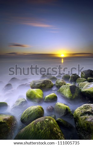 Sunset seen from rocky coast.