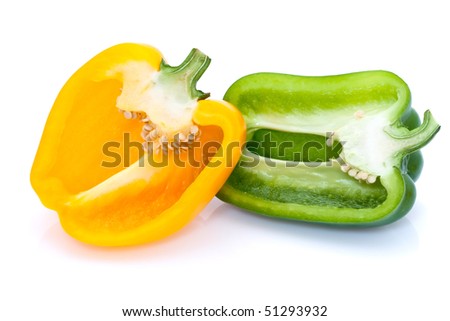A yellow and green pepper cut in half and placed side by side on a white background