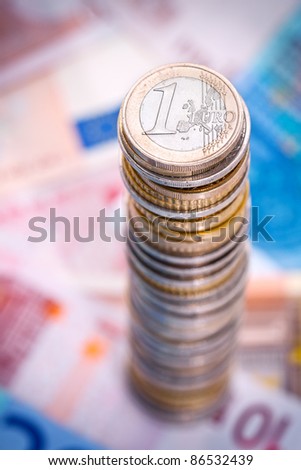 Big stack of euro coins with euro notes.