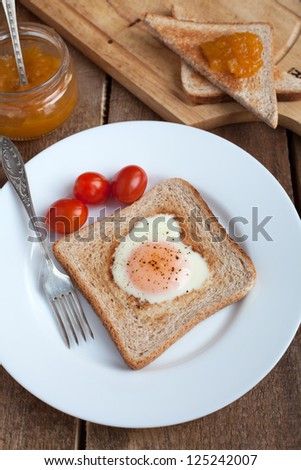 Toast with fried egg in the shape of heart and cherry tomatoes and Toasts with orange jam