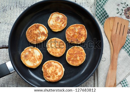 Delicious homemade cheese pancakes with raisin  in a pan on a wooden table