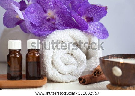 Spa still life with aromatic candle, orchid flower, towel, aromatic oils and cinnamon sticks, Focus On Foreground (Selective Focus)