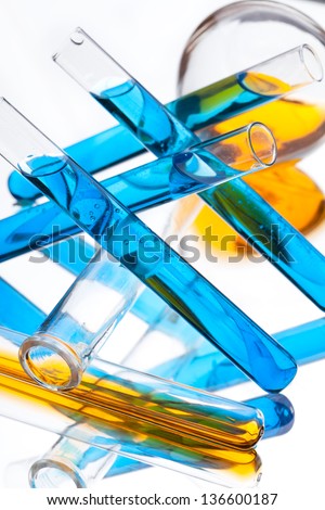 test tubes with colored liquid (yellow and blue) on a white background