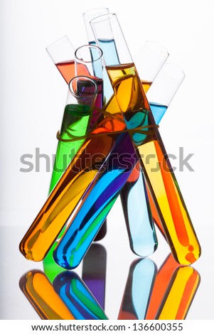 Seven test tubes with colored liquid in the spectrum colors on a white background