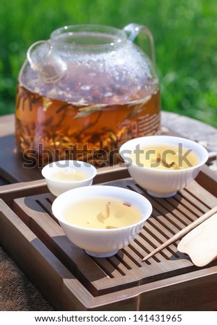 Traditional Chinese tea ceremony accessories, tea leaves White kidney Puer in boiling water in a glass pot, selective focus