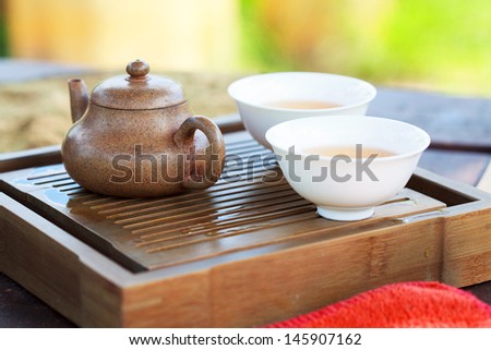 Traditional chinese tea ceremony accessories (tea pot and tea pair) on the tea table, selective focus on tea pot