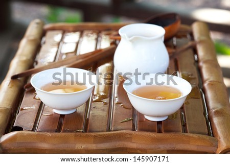 Traditional chinese tea ceremony accessories (tea cups and pitcher) on the tea table, selective focus