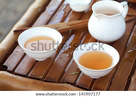 Traditional chinese tea ceremony accessories (cups and pitcher) on the tea table, selective focus
