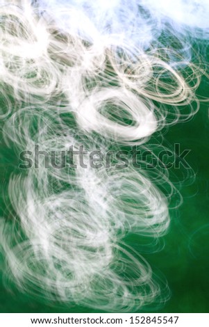 Photo art, bright Colorful light streaks abstract background in green, white and blue colors, effect of movement