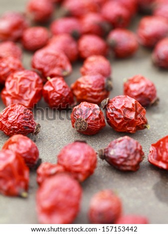 dried rose hips on a stone table, selective focus, some berries in focus, some are not