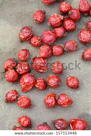 dried rose hips on a stone table, selective focus, some berries in focus, some are not