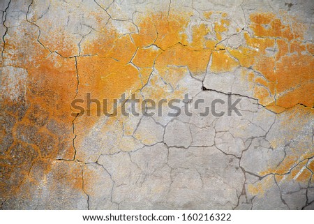 grunge concrete wall with cracks and orange paint, selective focus at the center