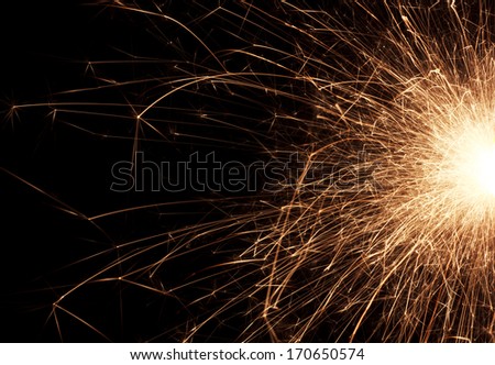 Fire spray from sparklers on black background, macro, selective focus