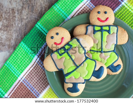 Two homemade Gingerbread men in protective khaki uniforms on Defender of the Fatherland Day
