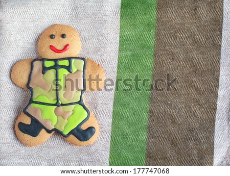 Homemade Gingerbread man in protective khaki uniforms on Defender of the Fatherland Day, place for text, close up