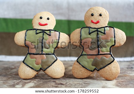 Homemade Gingerbread men in protective khaki uniforms on Defender of the Fatherland Day, selective focus on right man
